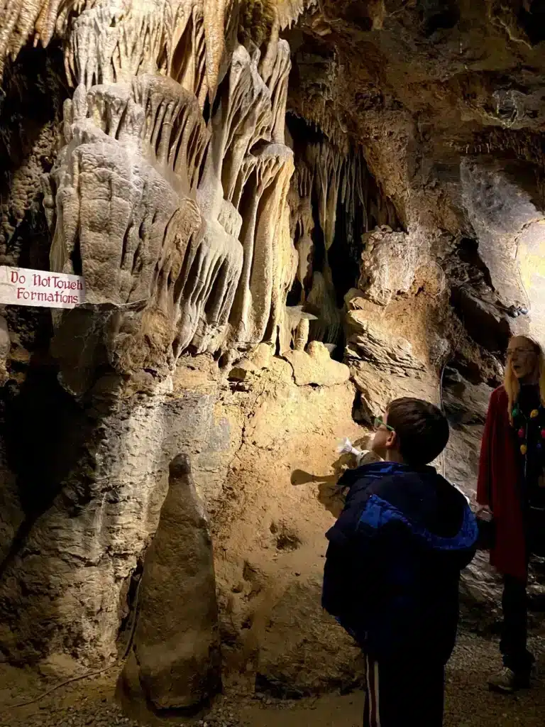 Child looking at a rock formation in a cave