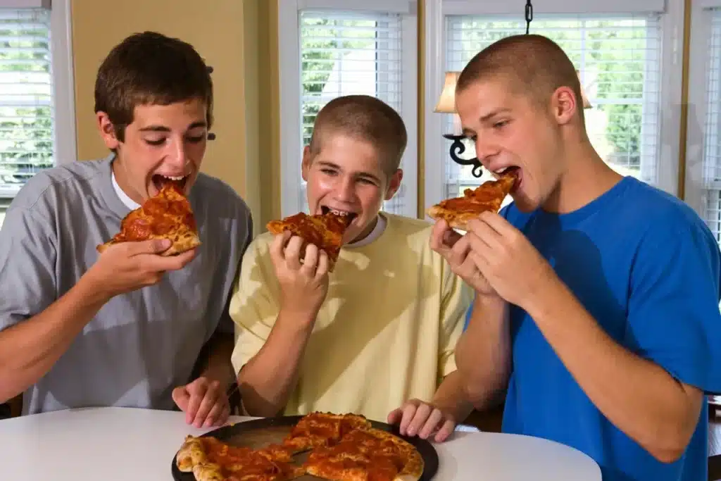 Three children eating pizza