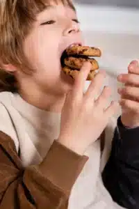 Child stuffing cookies into their mouth