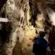 Child looking at a rock formation in a cave