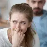 Woman looking upset and sitting in front of a man
