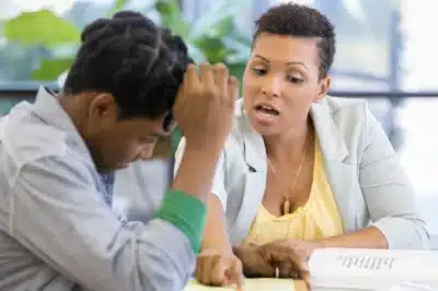 Woman showing child how to do their homework