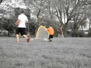 Man and child playing soccer