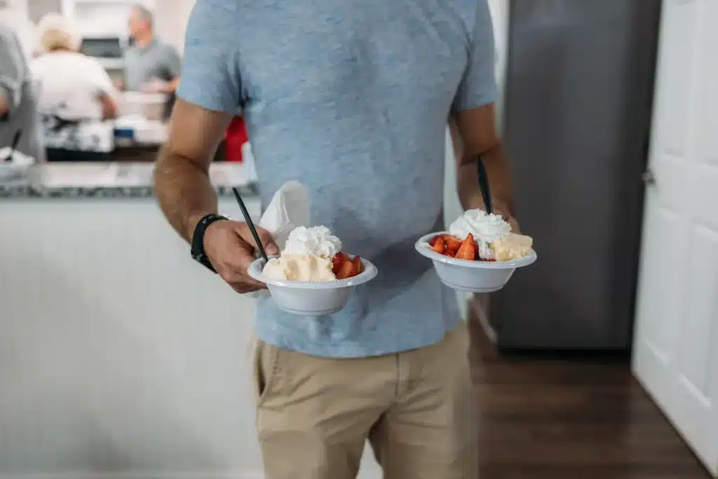 Man carrying two bowls of ice-cream