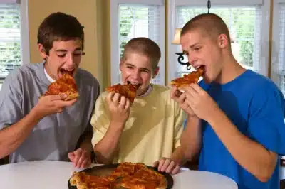 Three children eating pizza