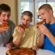 Three children eating pizza