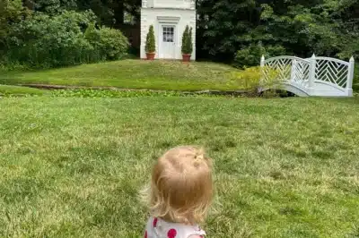 Little girl in field by pavillion