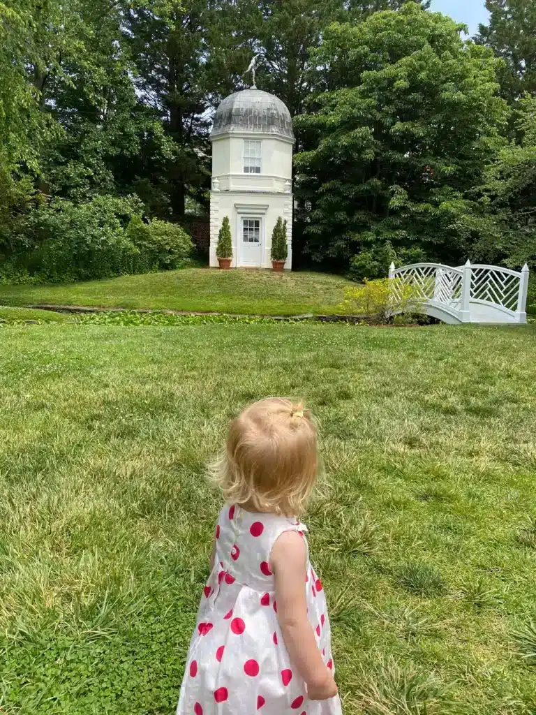 Little girl in field near pavillion