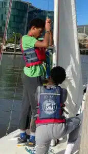 Two children attempting to hoist a sail