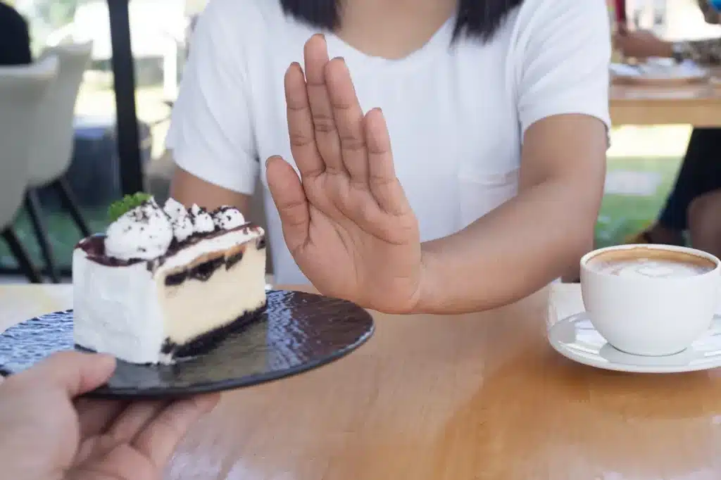 Woman refusing a slice of cake