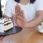 Woman refusing a slice of cake