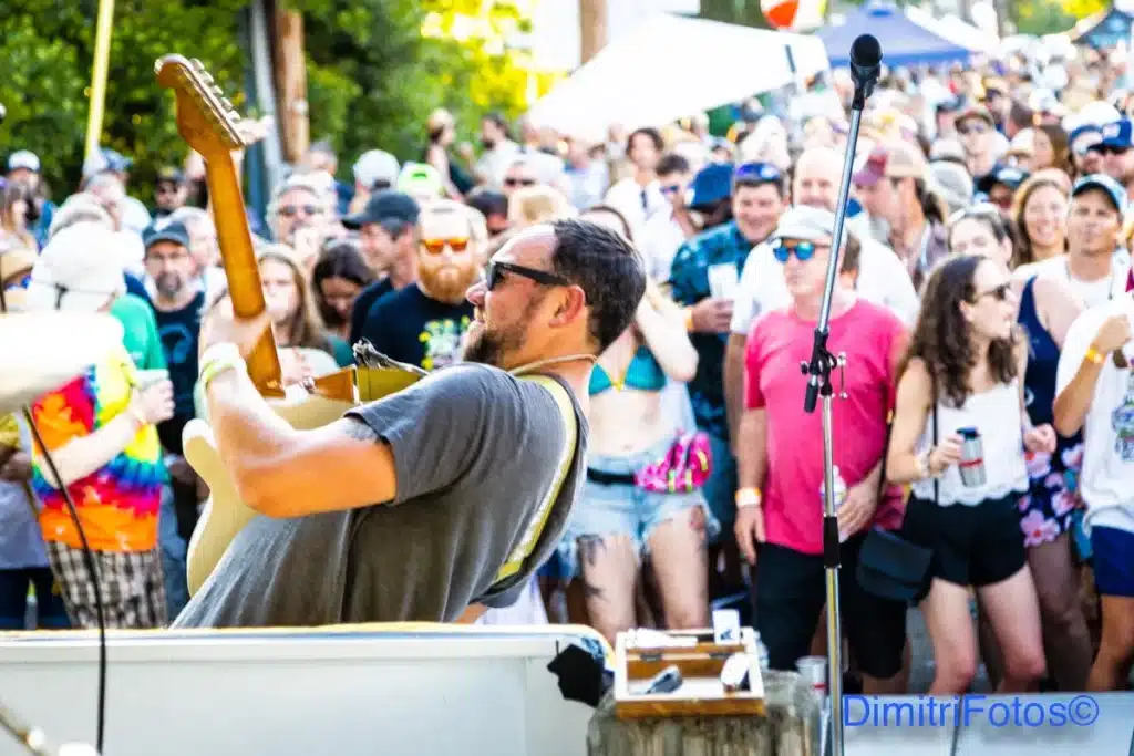 Guy jamming on guitar in front of large audience