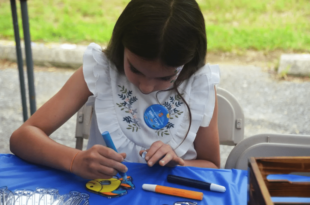 Girl coloring suncatcher outside