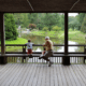 Little boy and grandpa sitting on a bridge overlooking river