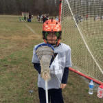 Young boy in lacrosse gear
