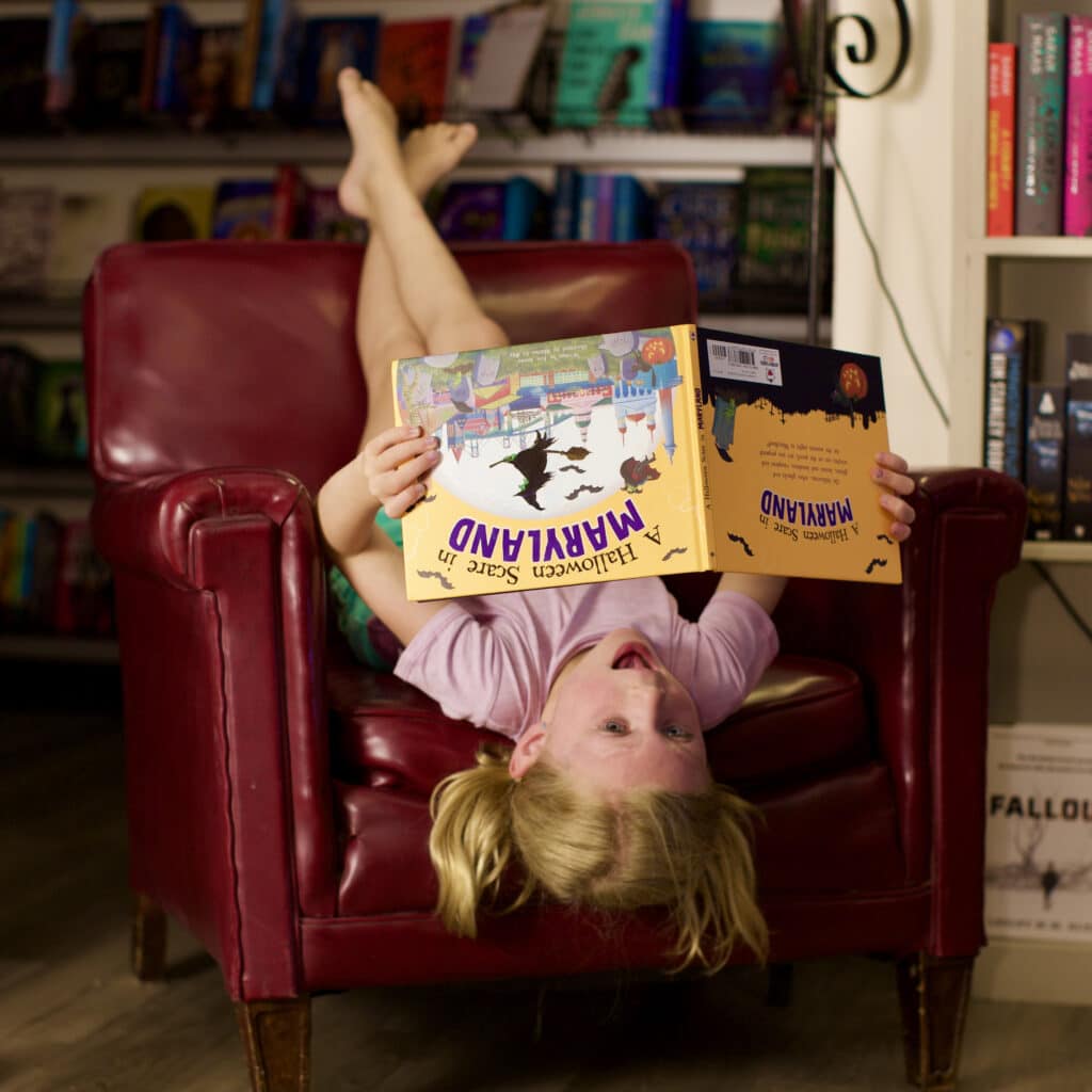 girl reading book upside down