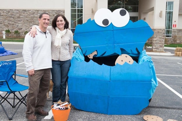 Adult couple standing next to cookie monster