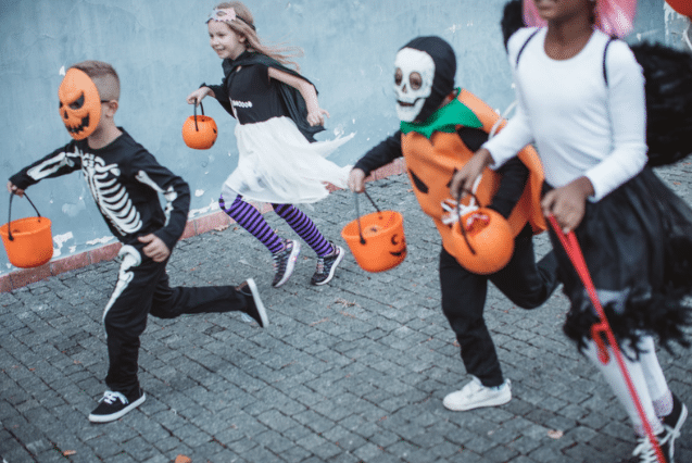 Kids in costumes trick or treating and running