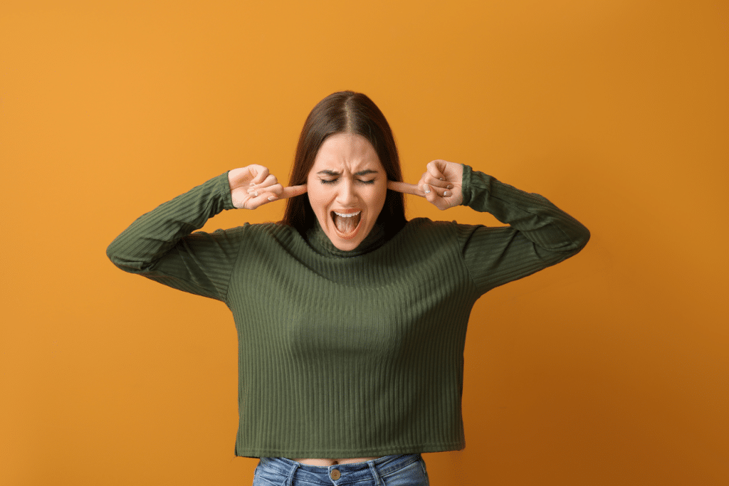 woman plugging her ears and screaming