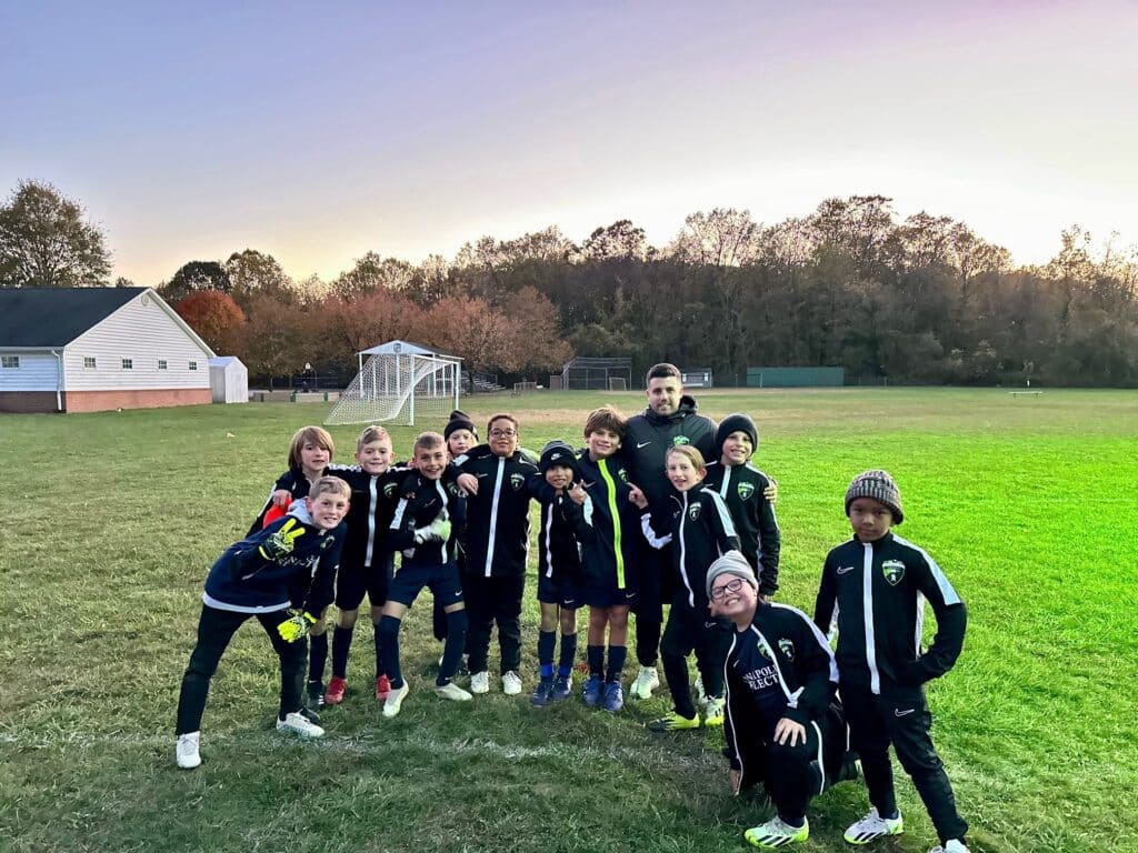 Boys soccer team posing on the pitch