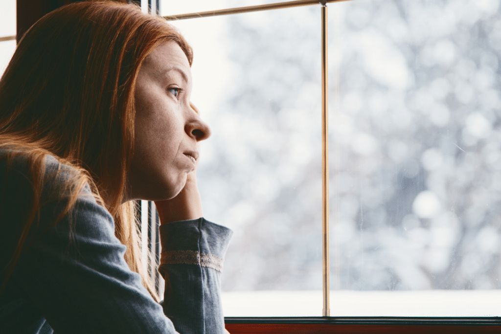 ominous woman looking out of winter with winter blues