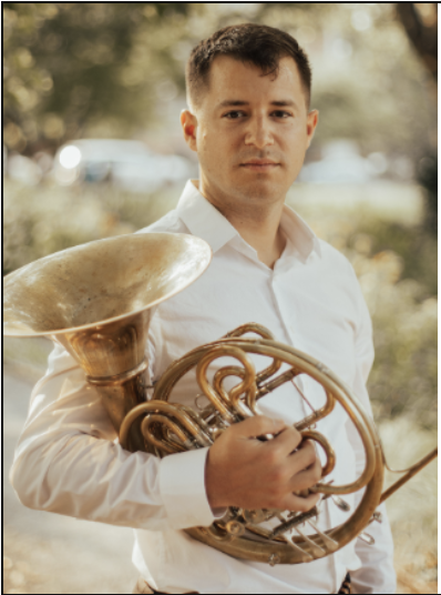 Man outside holding horn