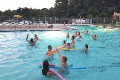 Multiple kids playing in the water at the Olde Mill Swim Club.