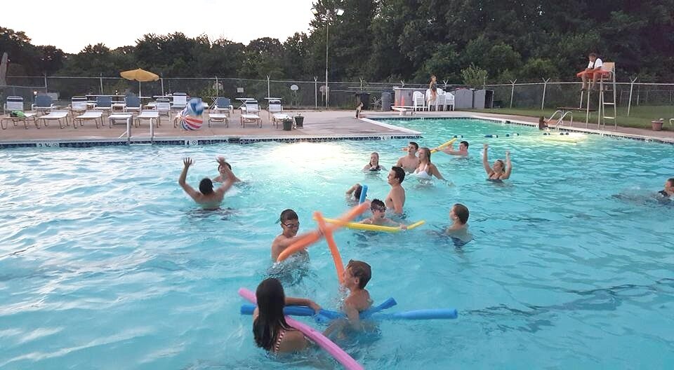 Multiple kids playing in the water at the Olde Mill Swim Club.