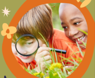 two kids looking at grass with a magnifying glass