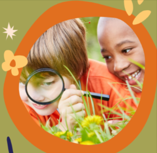 two kids looking at grass with a magnifying glass