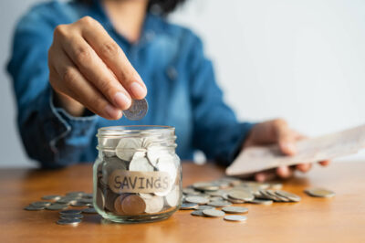 Woman putting change into a glass jar