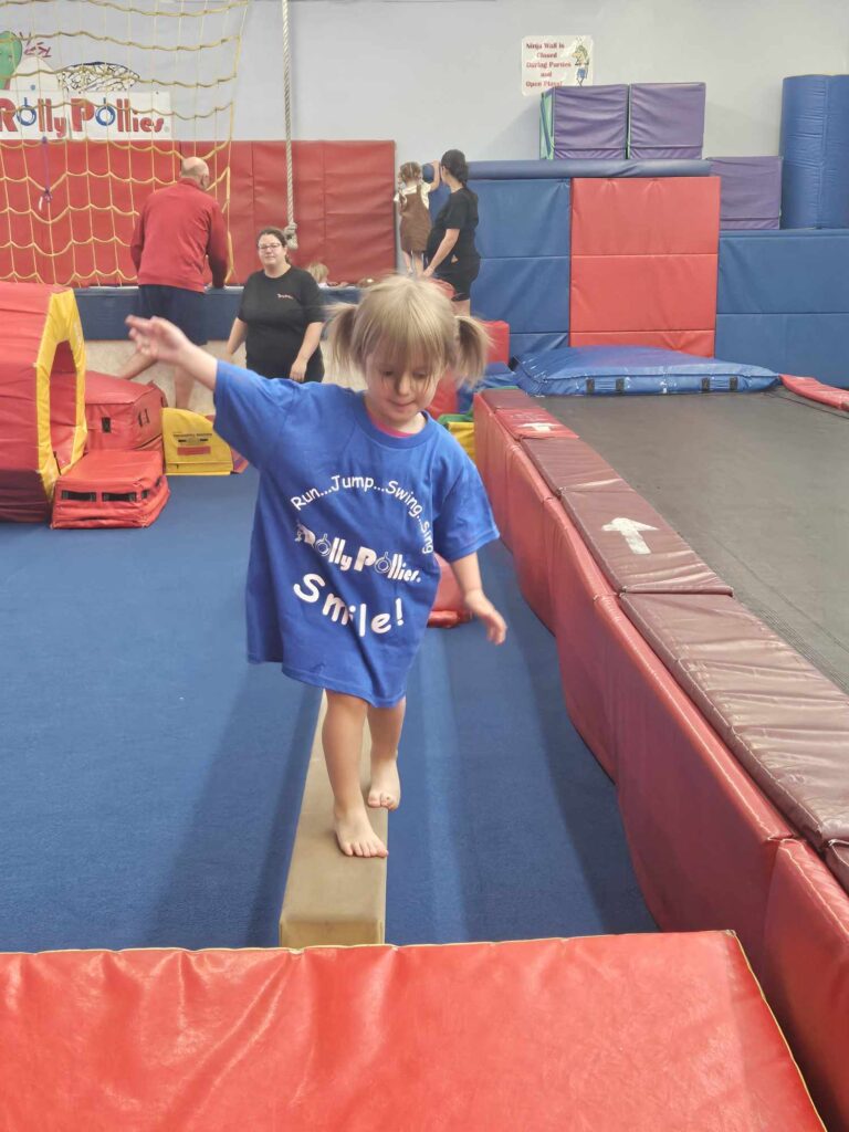 Girl in blue shirt on beam 768x1024