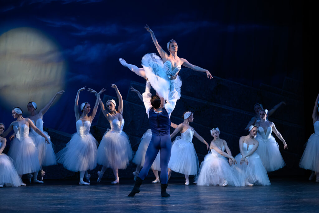 Ballet Theatre of Maryland dancer Lindsey Bell and guest artist Jackson Kettell pose in front of the Swan Corps de Ballet in Swan Lake.